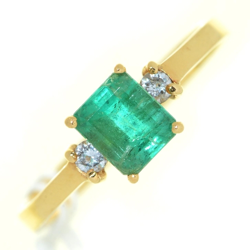 10 - An emerald ring, the step cut emerald flanked by diamonds, in gold marked 18k, 3g, size P... 