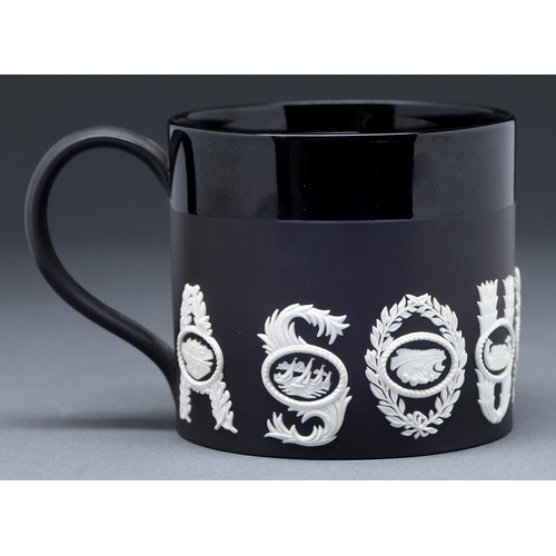 475 - A Wedgwood black basalt sporting mug, designed by Richard Guyatt CBE, 1966, ornamented in white jasp... 
