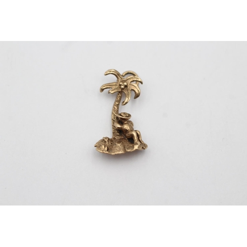 47 - 9ct gold palm tree island & person pendant (2.3g)