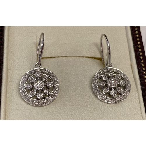 6 - A pair of 9ct white gold and diamond drop earrings in a modern circular and flower design.  Central ... 
