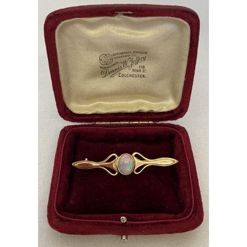 1001 - A gold Art Nouveau style bar brooch set with a central opal, tests as 9ct gold. With a vintage red v... 