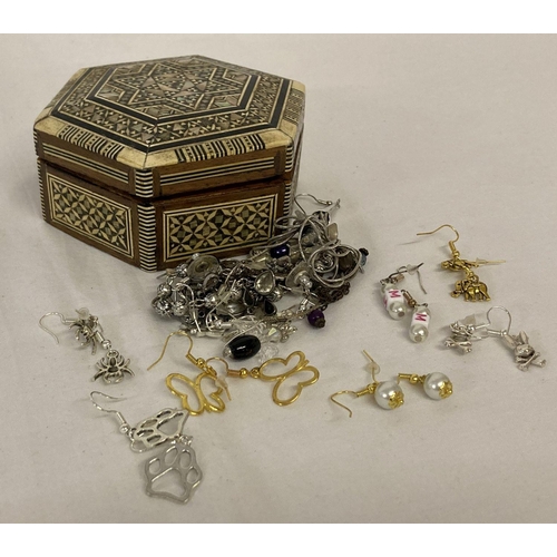 1008 - A small bone and mother of pearl trinket box containing a collection of costume jewellery earrings.