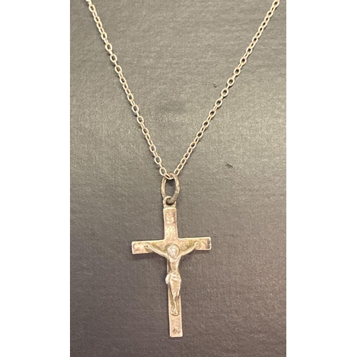 1010 - A silver crucifix pendant on a 18 inch silver fine curb chain. Back of pendant marked 'silver' with ... 