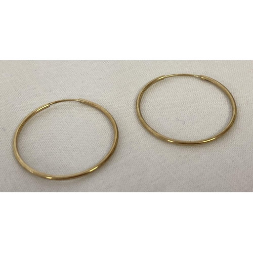 1018 - A pair of thin yellow gold hoop earrings, approx. 2.3cm diameter. Tests as 9ct gold. Total weight ap... 