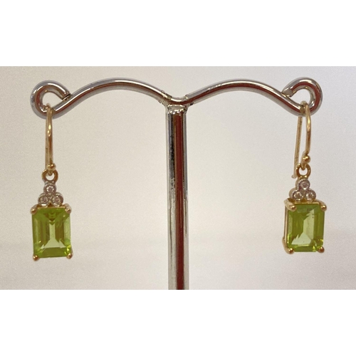 1020 - A pair of 9ct gold peridot and diamond drop style earrings. Each earring set with a emerald cut peri... 