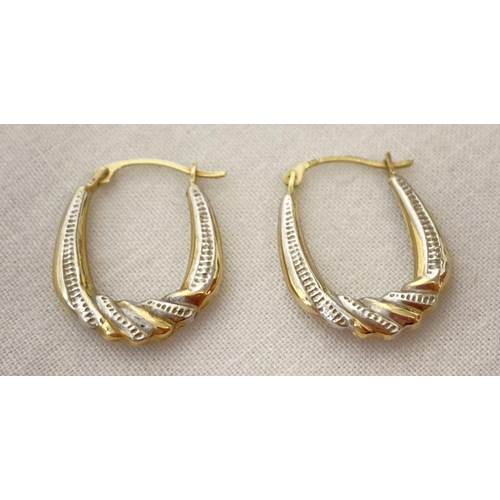 1023 - A pair of yellow and white gold twist design hoop style earrings. Posts marked 375. Each earring app... 