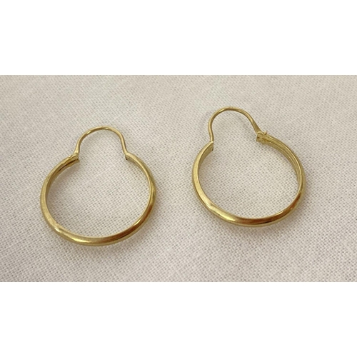 1027 - A small pair of gold hoop style earrings. Indistinct markings to posts. Tests as 9ct. Each earring a... 