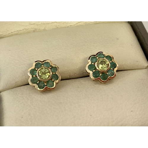 1033 - A pair of 9ct gold emerald and peridot flower design stud earrings. Each earring has a central round... 