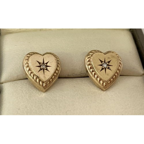1035 - A pair of 22ct gold heart shaped earrings each set with a small diamond. Vintage earrings have been ... 