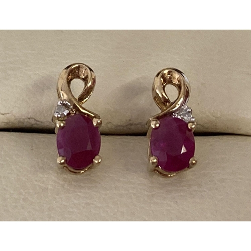 1043 - A pair of 9ct gold ruby and diamond stud style earrings with gold twist design. Each earring set wit... 
