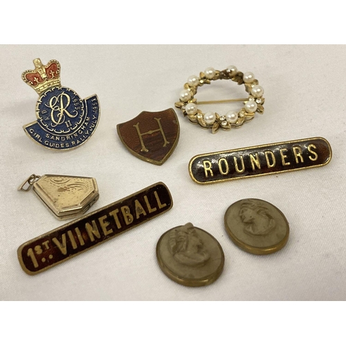 1051 - A small collection of vintage jewellery and enamel badges. To include a rolled gold locket, a 1953 S... 