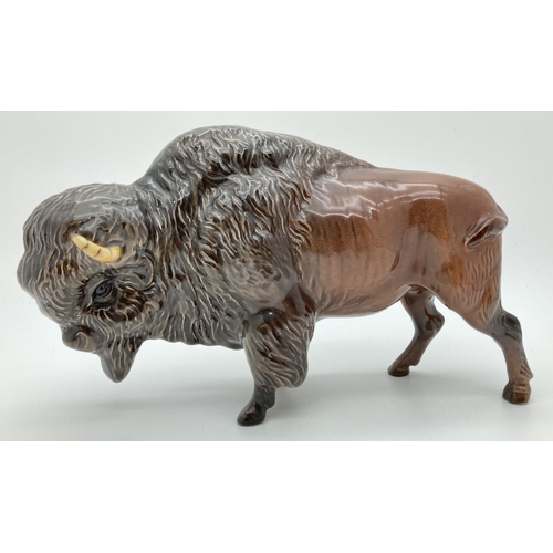 A Beswick ceramic bison figure #1019 in brown gloss finish, with circular backstamp. Approx. 13.5cm tall x 24cm long.