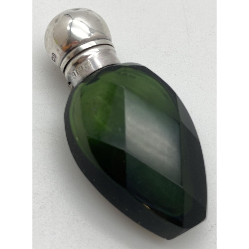 1043 - A Victorian green glass faceted scent bottle with hallmarked silver lid. Hinge lidded bottle, fully ... 