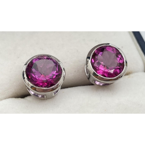 1004 - A pair of modern 9ct white gold and hot pink sapphire earrings. Fully hallmarked to posts, with 'DK'... 