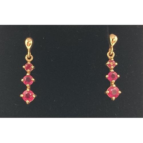 1016 - A pair of 9ct yellow gold ruby set drop earrings, fully hallmarked to posts. Complete with butterfly... 