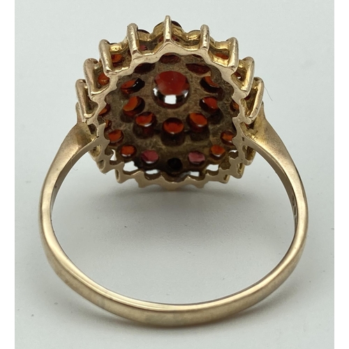 1018 - A 9ct gold dress ring set with a large cluster of garnets, fully hallmarked inside band. Ring size Z... 