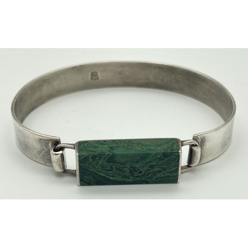 1058 - A modern design silver bracelet set with an oblong of green malachite. Hook and eye fastening. Silve... 