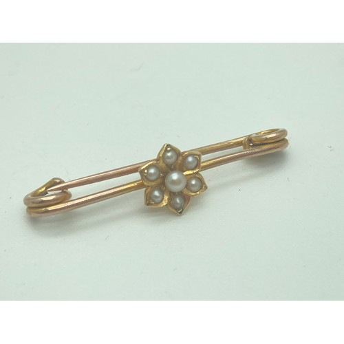 1025 - A vintage 9ct gold bar brooch with seed pearls set in a flower design. Safety pin style fixing. Appr... 