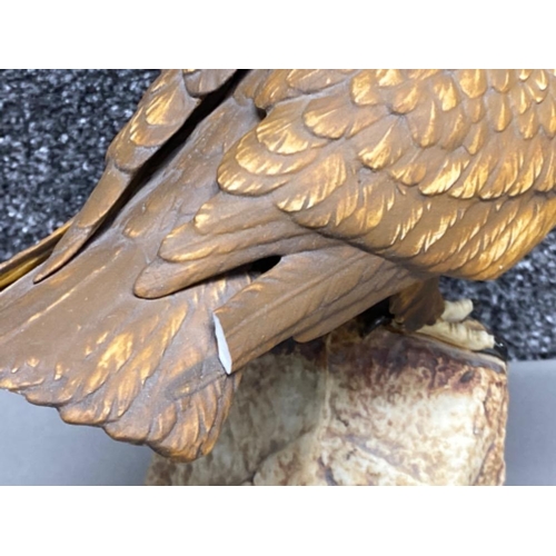 33 - Eagle ornament on rock signed Tommocloe to the base (damage to back of wing)