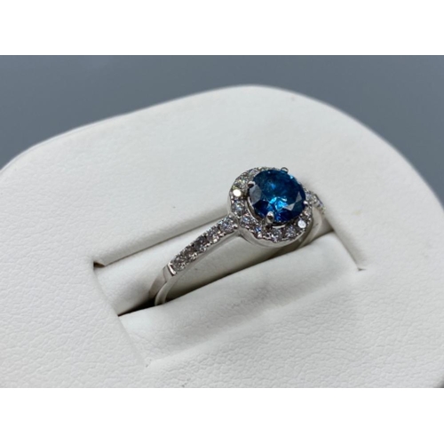 34 - 18ct white gold ring comprising of a 0.60ct blue diamond surrounded by a total of 0.30cts of diamond... 