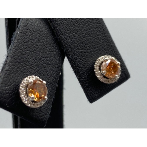 41 - 18ct White Gold Earrings comprising of a 0.60ct fancy coloured diamond center stone with 0.19ct tota... 