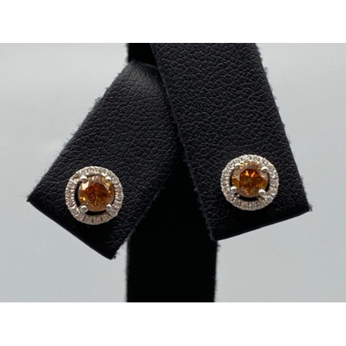 53 - 18ct White Gold Earrings comprising of a 0.60ct fancy coloured diamond center stone with 0.18ct tota... 