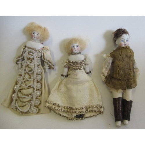 23 - Three shoulder head dolls house dolls, comprising two similar ladies in beaded dresses and a boy in ... 