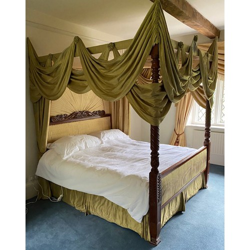 A French four-poster bed, carved headboard and spiral turned posts, with green silk hangings, complete with unused mattress, height approx. 215cm, the mattress 190x130cm, each post adds approx 20cm