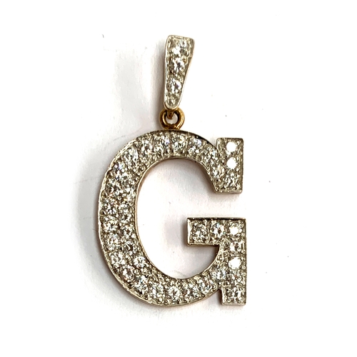 9 - A 9ct gold 'G' pendant, set with white stones, approx. 6.6g