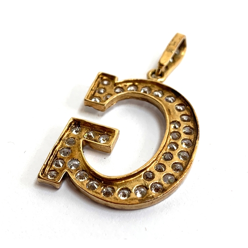 9 - A 9ct gold 'G' pendant, set with white stones, approx. 6.6g