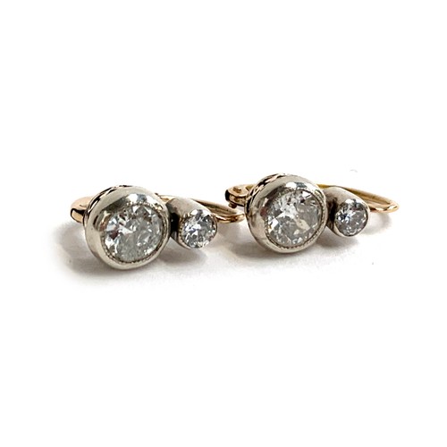 41 - A pair of 14ct gold and two stone diamond earrings with platinum fronts, the larger diamonds in a pi... 