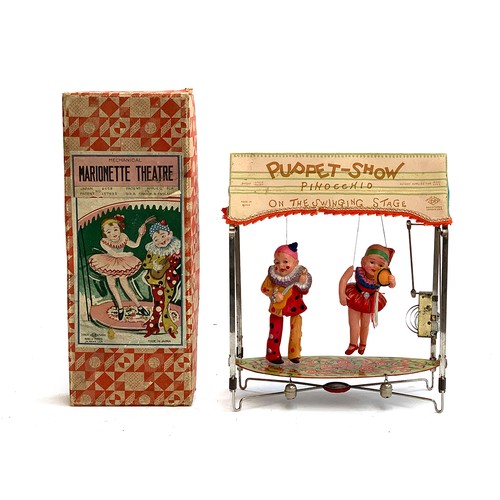 A 1930s Japanese Mechanical Marionette Theatre, comprising celluloid ballerina and clown with a  tinprinted platform and clockwork motor, with original box