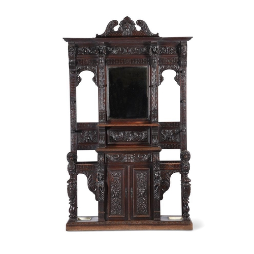 A carved oak hall stand in antiquarian taste late 19th or early 20th century with ivorine label to the drawer 'from Charles Jenner & Comp. Edinburgh' 241cm high, 140cm wide, 42cm deep