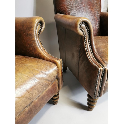 59 - Pair of leather upholstered armchairs raised on turned legs { 94cm H X 75cm W X 84cm D }.