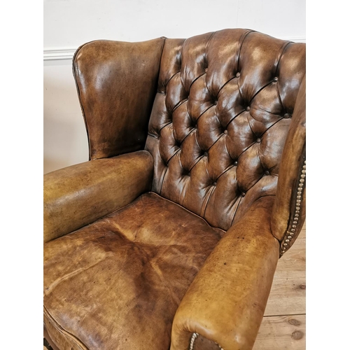 39 - Pair of early 20th C. hand died brown leather deep buttoned wing back chairs with brass studs raised... 