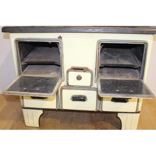 34 - Cast iron and enamel stove with enamel back splash {100 cm H x 91 cm W x 41 cm D}.