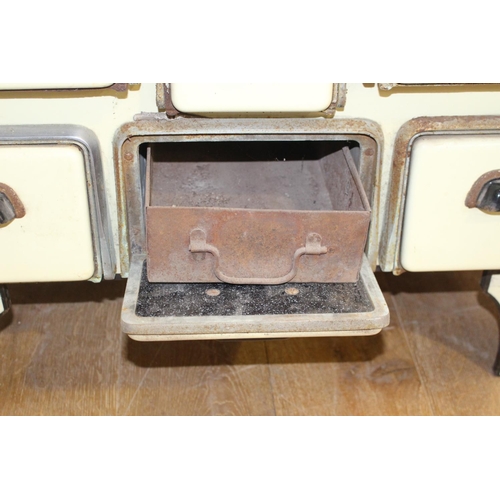 34 - Cast iron and enamel stove with enamel back splash {100 cm H x 91 cm W x 41 cm D}.