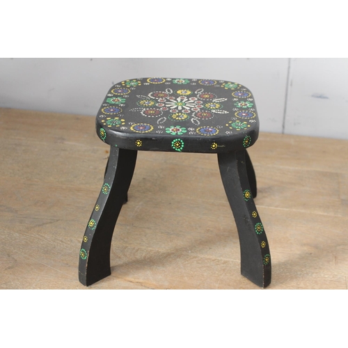 48 - Black wooden milking stool with painted floral design {28 cm H x 30 cm W x 30 cm D}.
