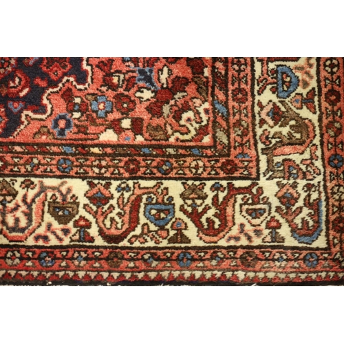 2 - A VINTAGE HERATI WOOL RUG the central panel filled with stylized flowerheads and foliage within a co... 