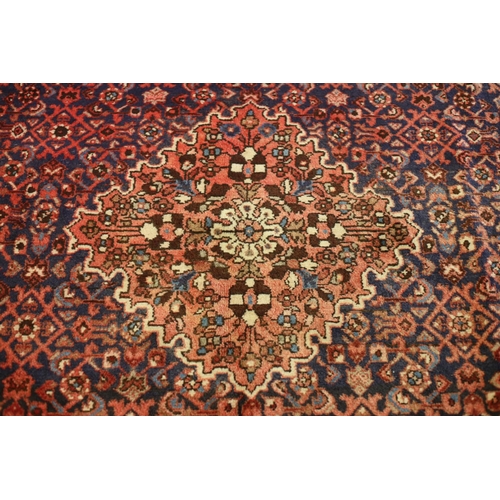 2 - A VINTAGE HERATI WOOL RUG the central panel filled with stylized flowerheads and foliage within a co... 