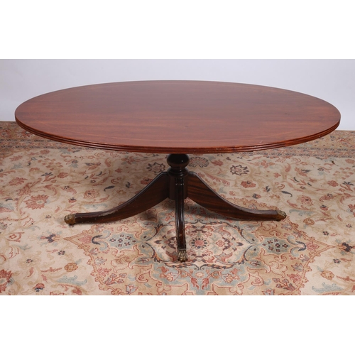 31 - A MAHOGANY AND SATINWOOD INLAID COFFEE TABLE of oval outline with reeded rim on quadruped splayed le... 