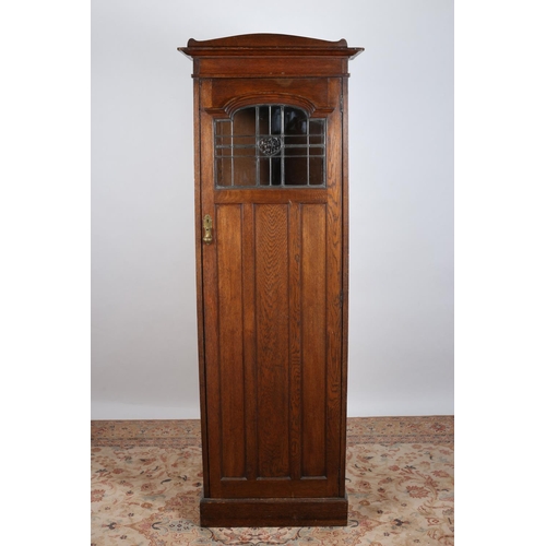 46 - AN ARTS AND CRAFTS HALL CUPBOARD with lead glass clear glass and blind panelled door containing bras... 