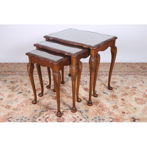 48 - A NEST OF THREE WALNUT TABLES each of serpentine outline with glazed inset on cabriole legs with pad... 