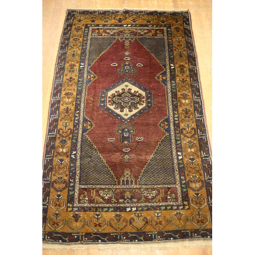 5 - AN AFGHAN TRIBAL VINTAGE WOOL RUG the wine indigo and brown ground with central panel filled with ce... 