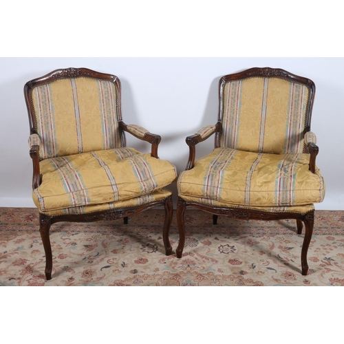 16 - A PAIR OF CONTINENTAL STAINED BEECHWOOD AND UPHOLSTERED ELBOW CHAIRS each with a carved top rail wit... 