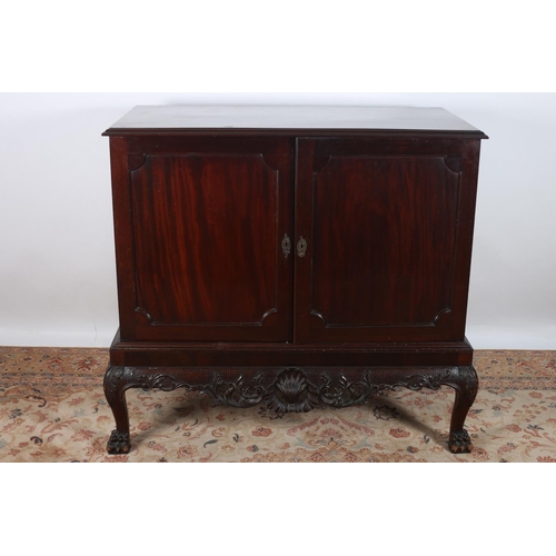9 - A CHIPPENDALE DESIGN MAHOGANY SIDE CABINET of rectangular outline the shaped top above a pair of pan... 