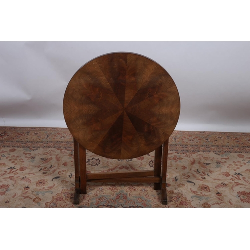 24 - A VINTAGE HARDWOOD FOLDING TABLE the circular segmented top on standard end supports with moulded le... 