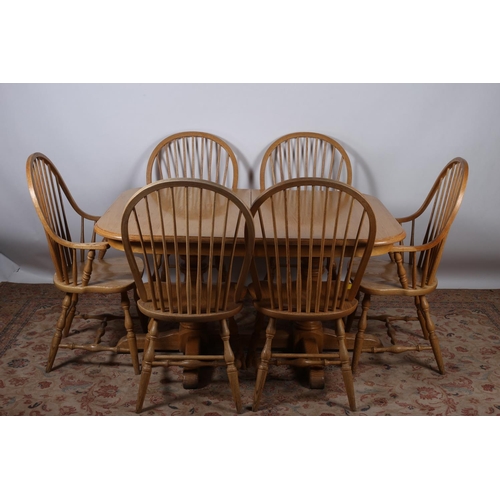 37 - A NINE PIECE BEECHWOOD DINING ROOM SUITE comprising eight spindle back chairs including a pair of el... 