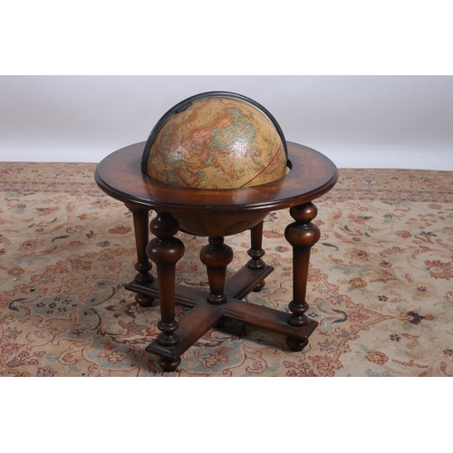 38 - A WALNUT CROSS BANDED GLOBE ON STAND the circular moulded top raised on cylindrical tapering support... 