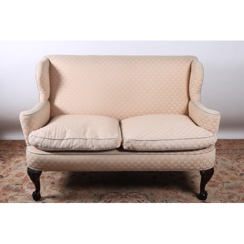45 - A CHIPPENDALE DESIGN MAHOGANY AND UPHOLSTERED TWO SEATER WING BACK SETTEE the rectangular shaped bac... 